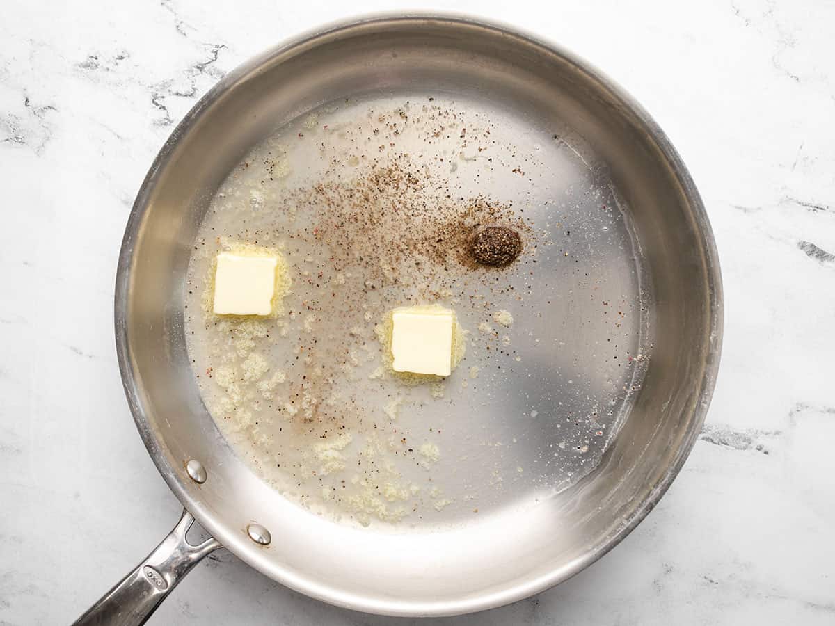 Pasta water, butter, and pepper in a pan.