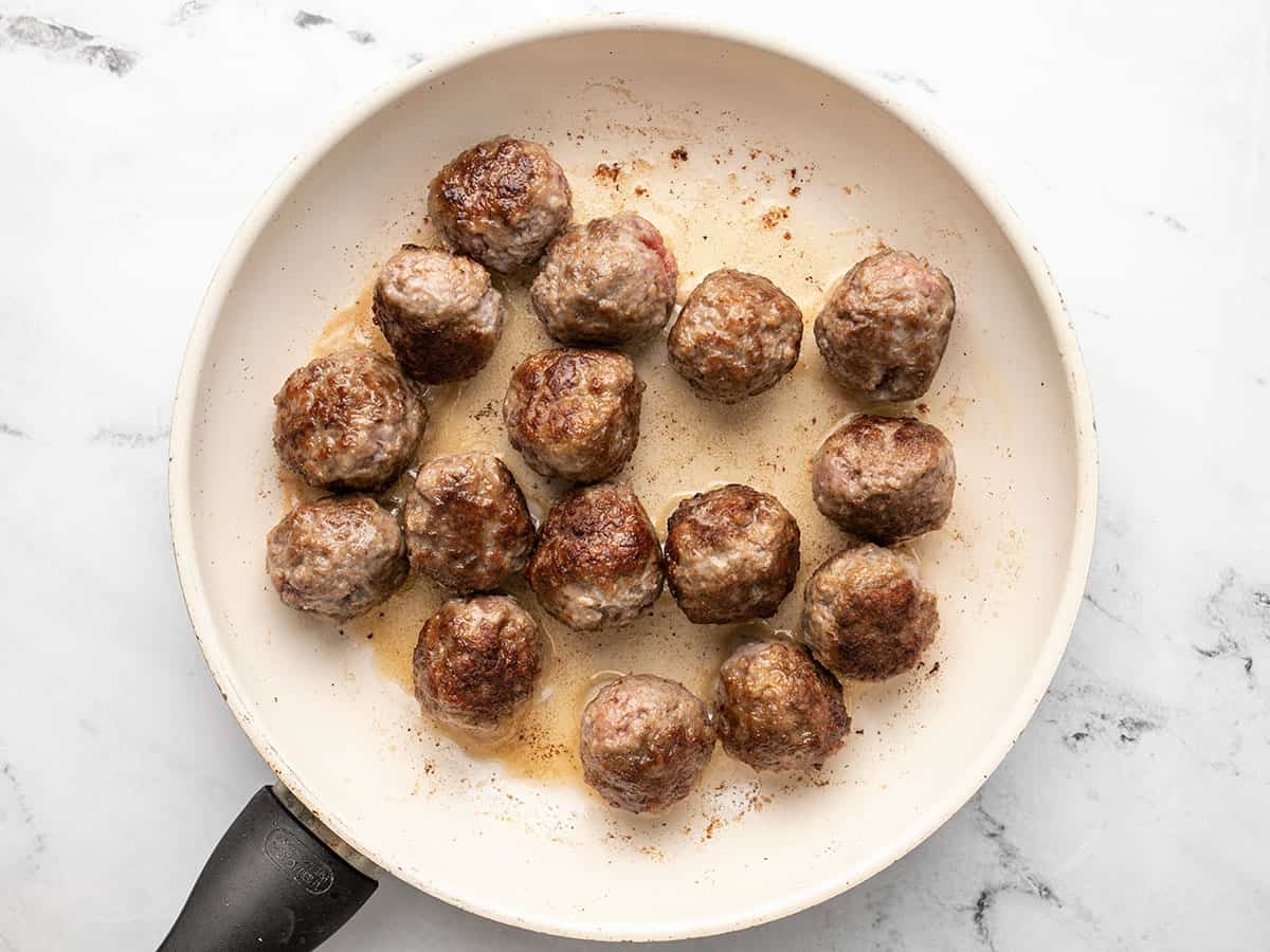 Browned meatballs in the skillet.