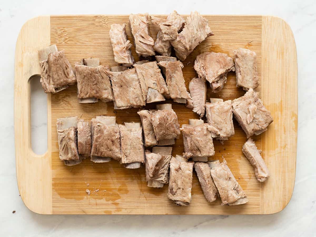 Chopped pork ribs on a wood cutting board.