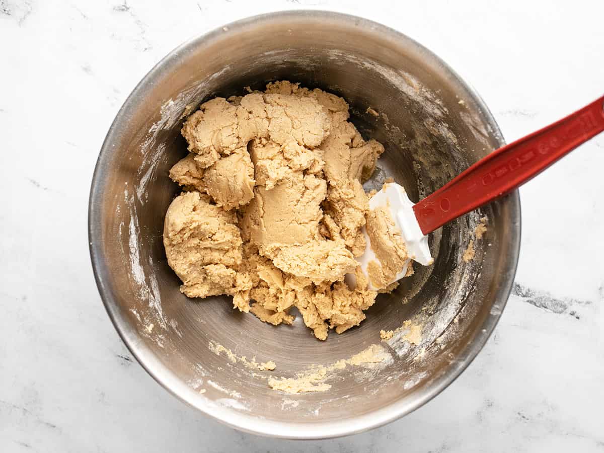 Peanut butter cookie dough in the bowl with a spatula.
