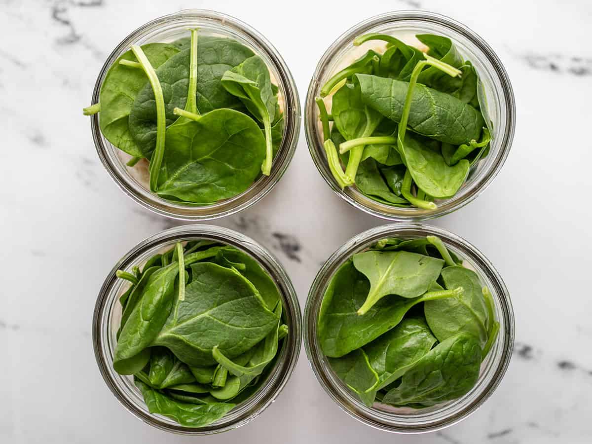 Fresh spinach added to the jars. 
