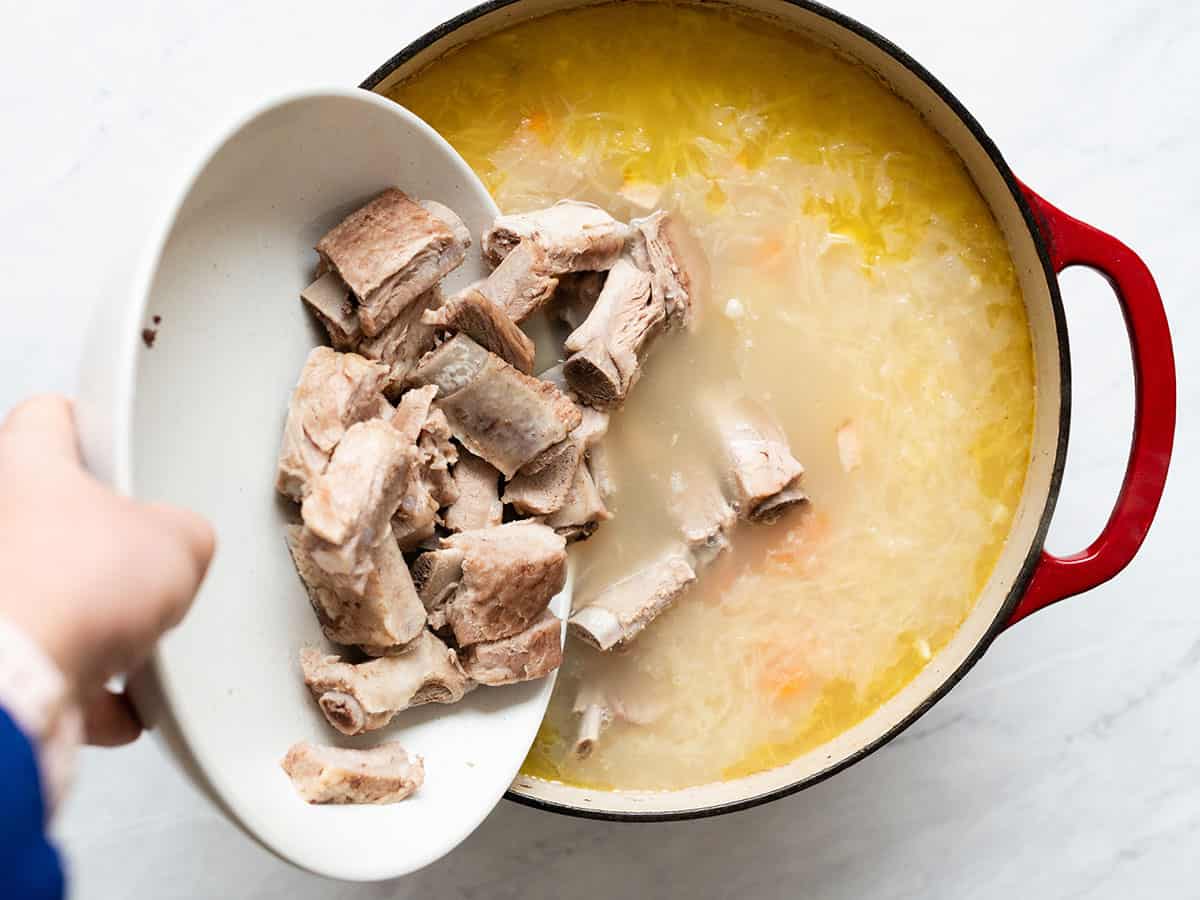 Pork ribs being added back to the soup.