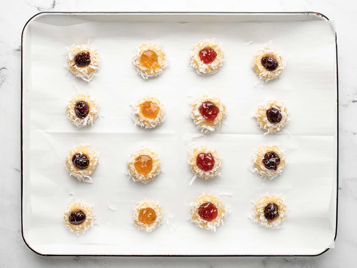 Cookies filled with jam on the baking sheet.