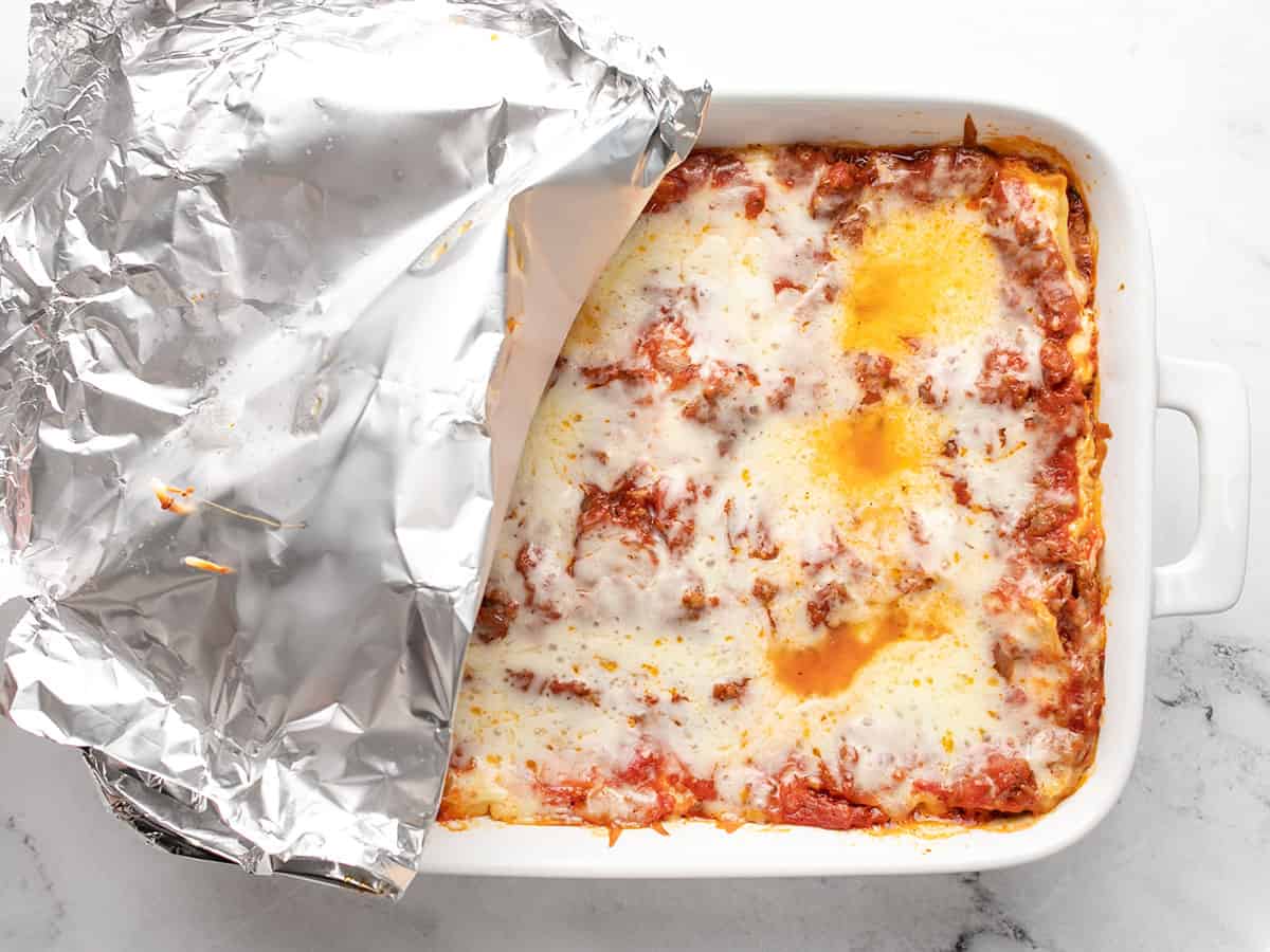 Baked lasagna with the foil pulled back. 
