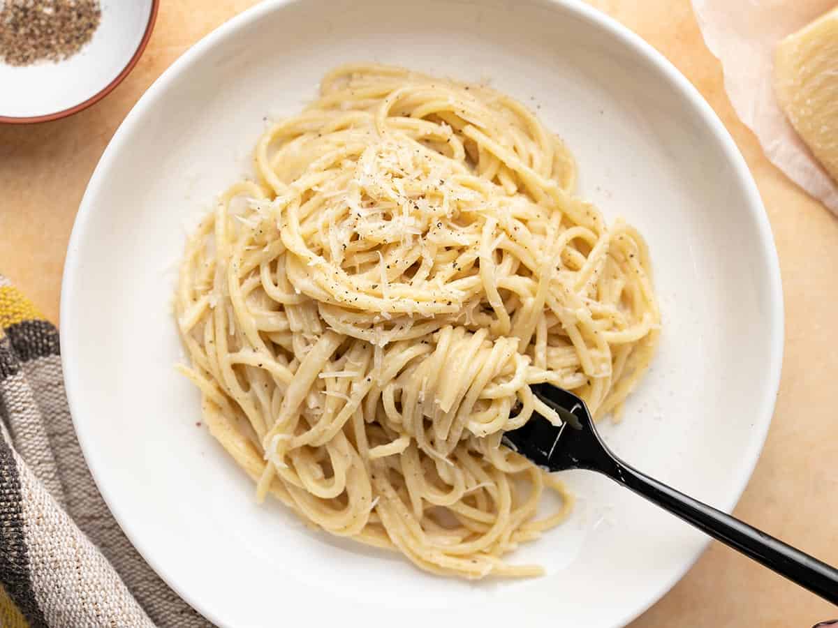 Overhead shot of finished Cacio e Pepe on a plate with a fork in it.