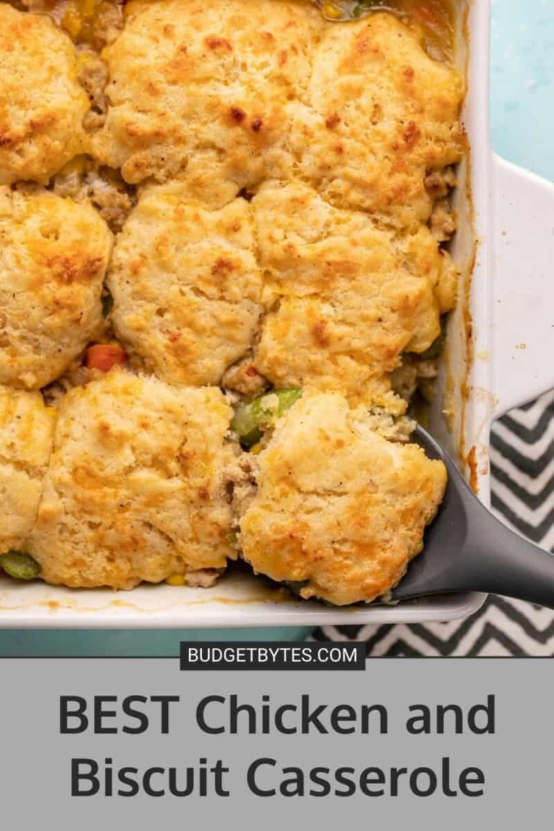 Overhead view of cooked chicken and biscuit casserole with serving spoon.