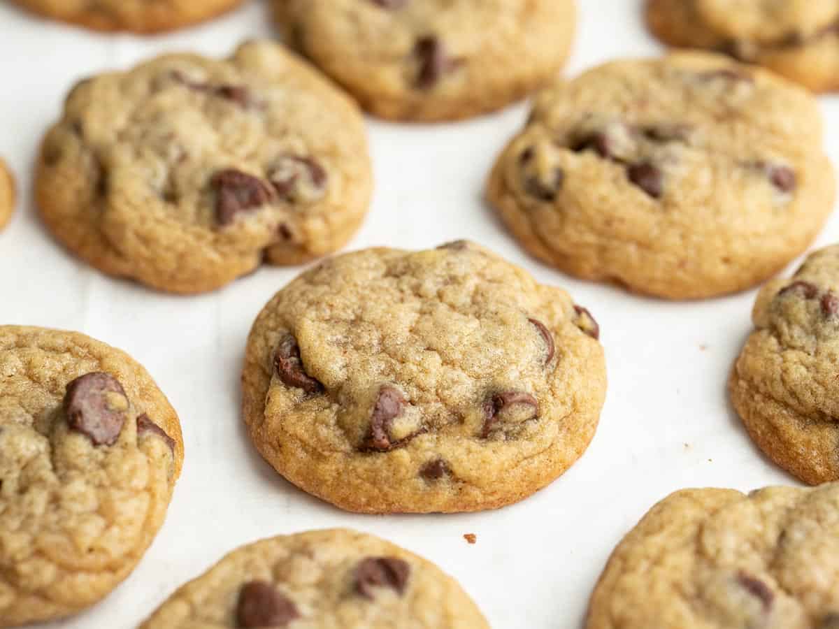 Side view of chocolate chip cookies on a white surface, close up. 