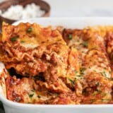 Side view of a slice of lasagna being lifted out of the pan.