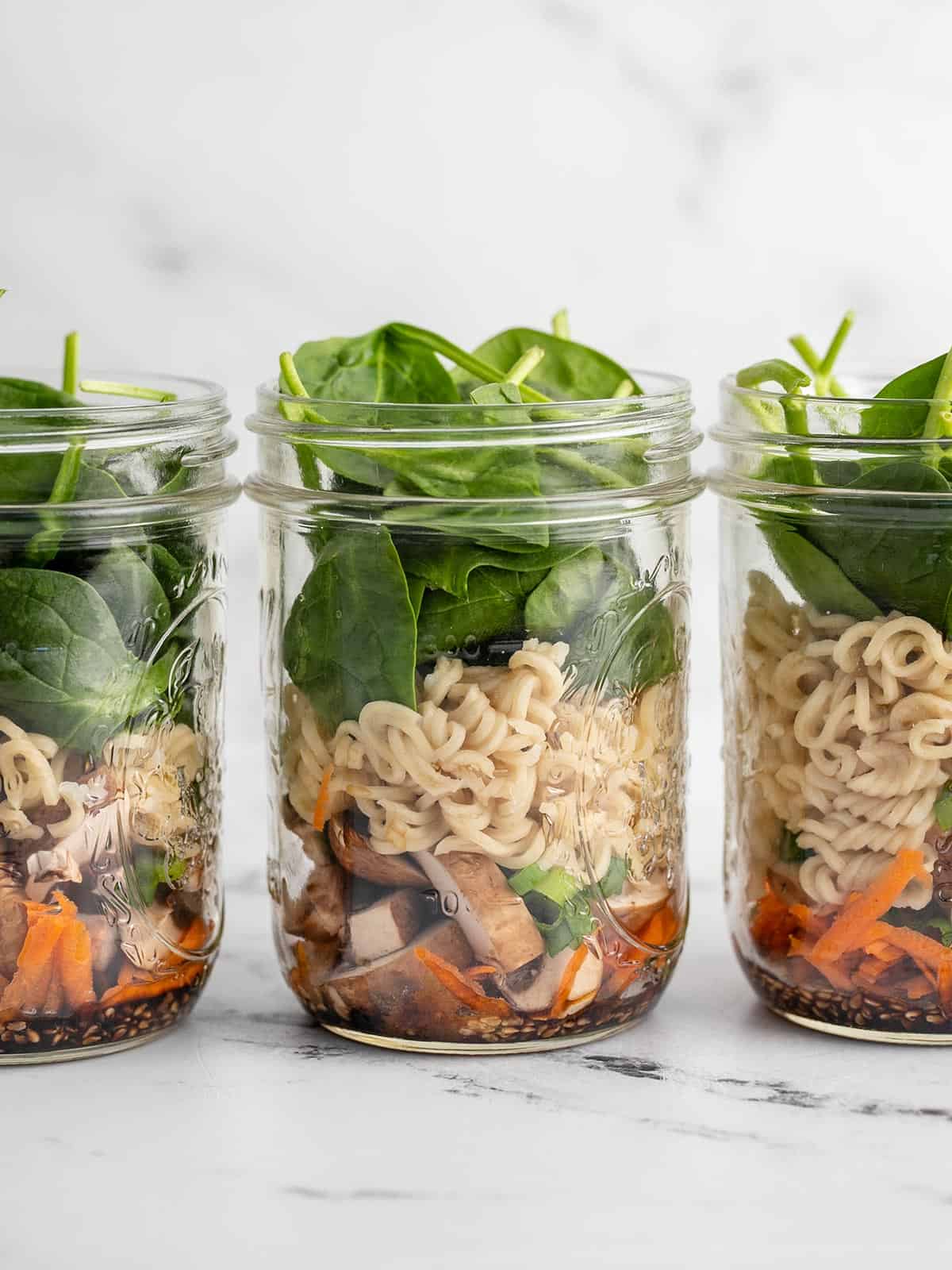 Noodle soup jars lined up in a row, viewed from the side.