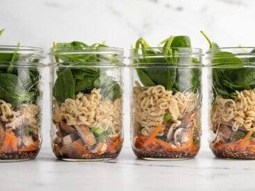 Four noodle soup jars lined up in a row.