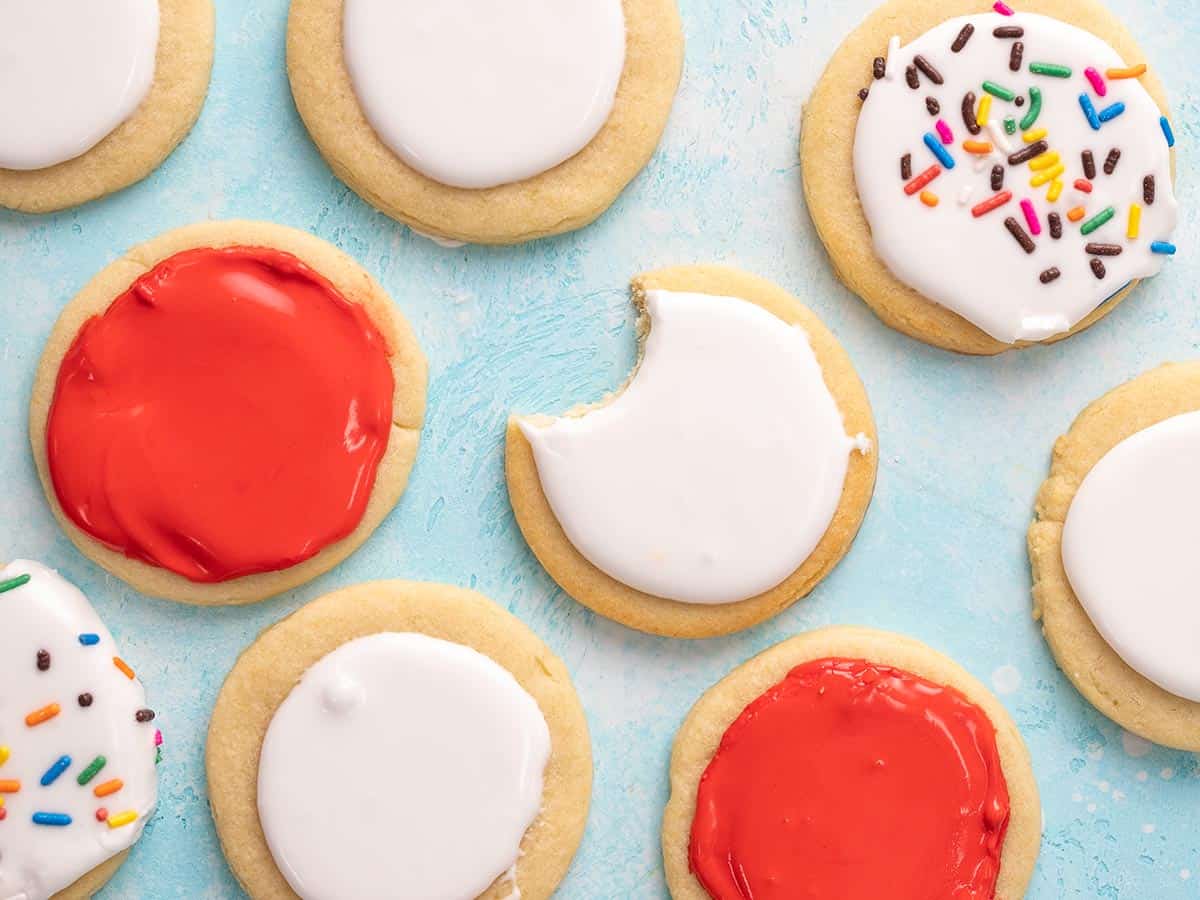 Overhead shot of round red and white sugar cookies, with a bite taken out of one of them.