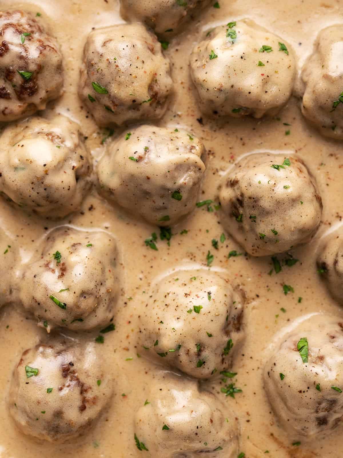 Close up overhead view of meatballs in a cream sauce.