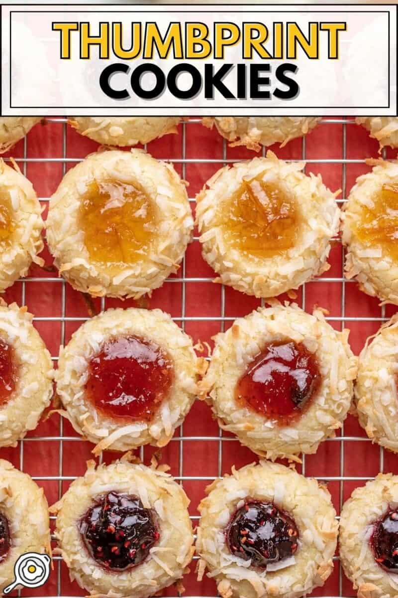 Overhead view of jam thumbprint cookies lined up on a wire cooling rack.