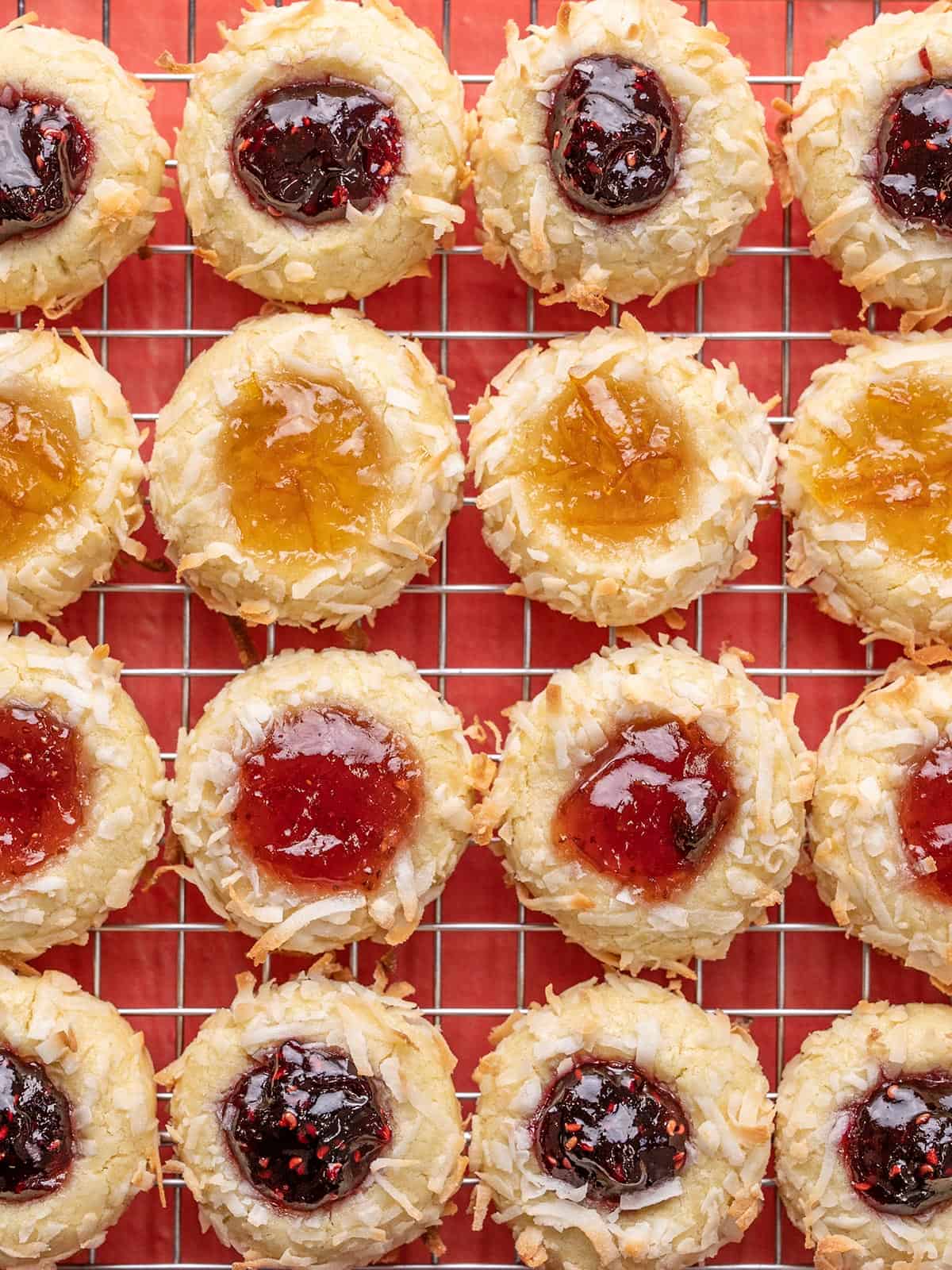 thumbprint cookies lined up closely on a wire cooling rack.
