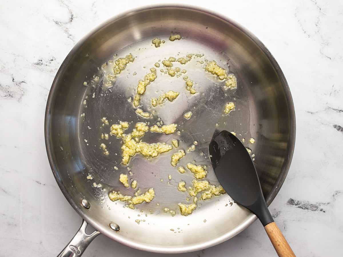 Minced garlic being sauteed in olive oil.