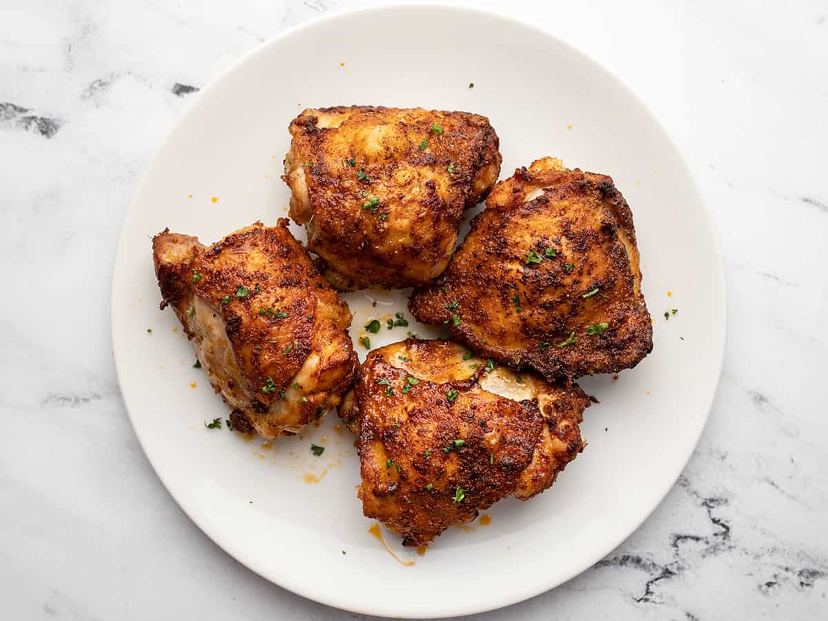 Finished air fryer chicken thighs on a plate.