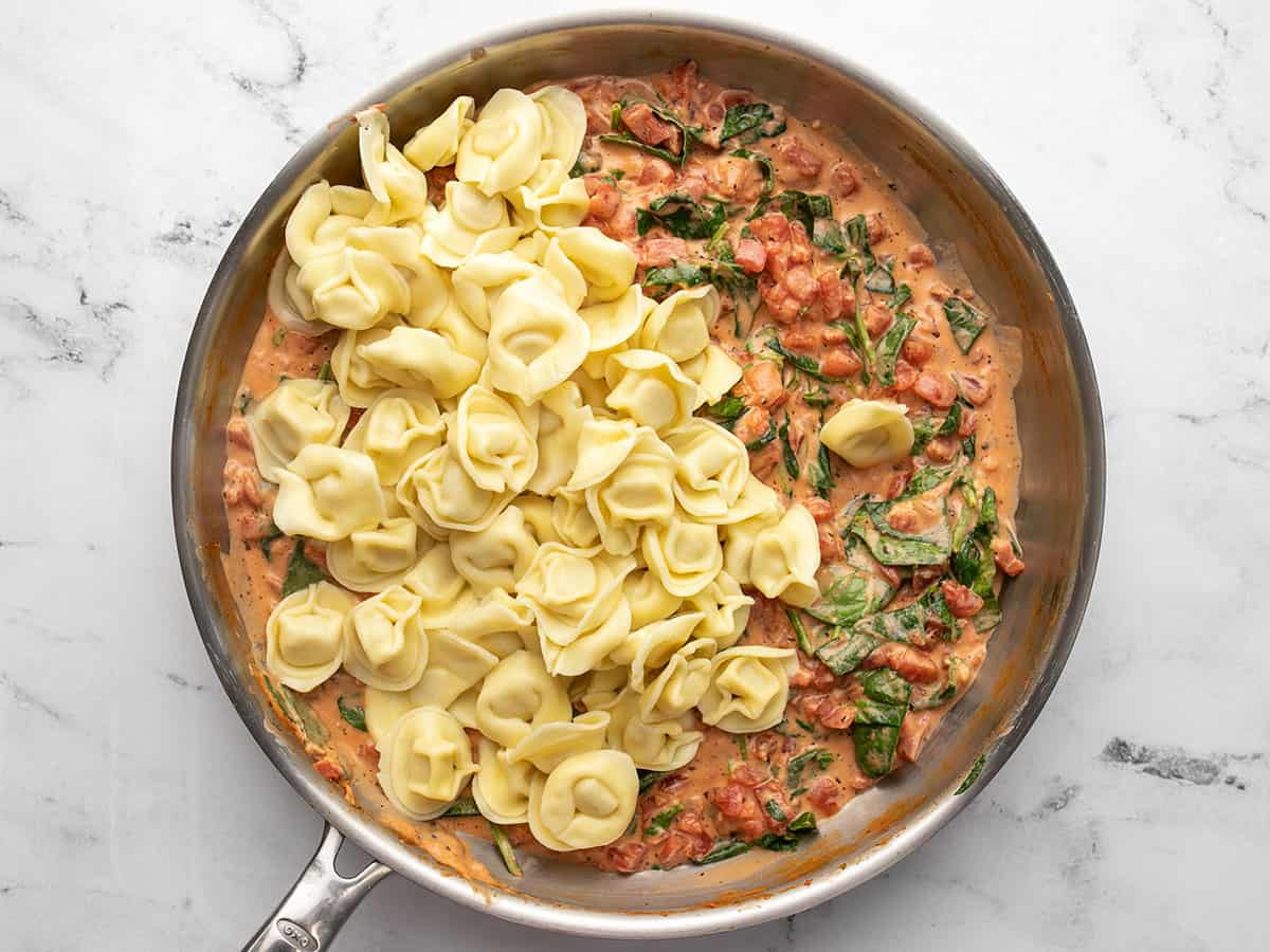 Drained tortellini added to the skillet.