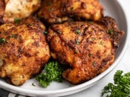 close up side view of air fryer chicken thighs on the plate.