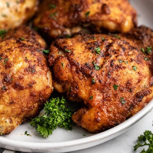 close up side view of air fryer chicken thighs on the plate.