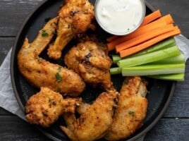 Overhead shot of air fryer chicken wings on a black plate.