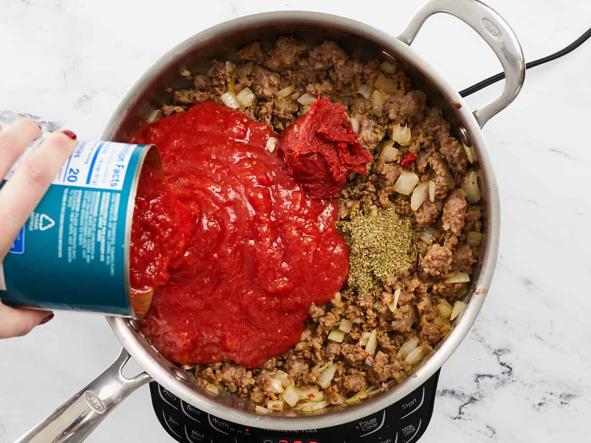 Tomatoes and spices added to the skillet.