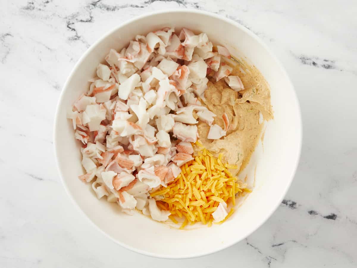 Overhead shot of crab and cheese in a white bowl.