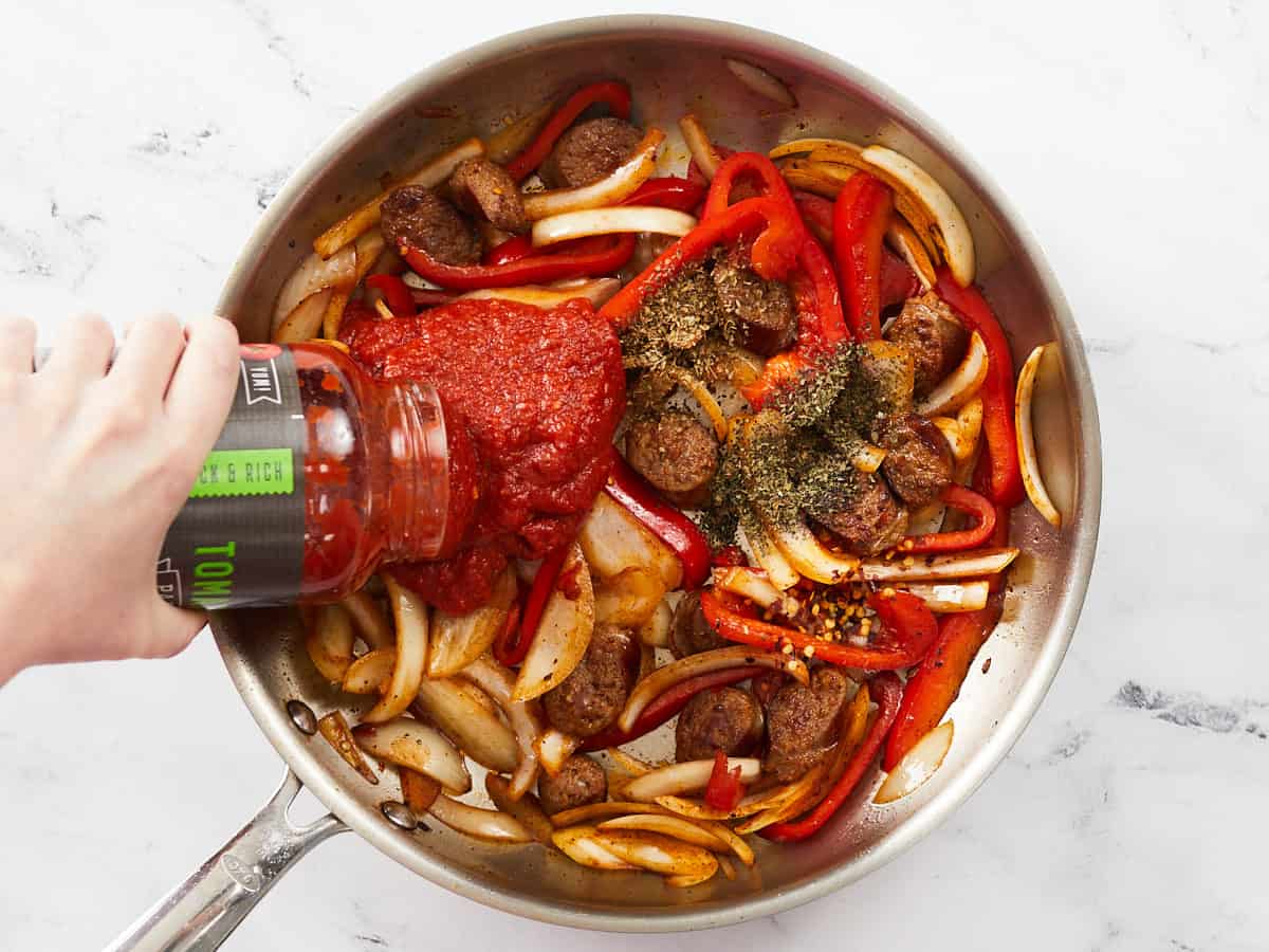 Sauce and seasoning being added to the skillet.