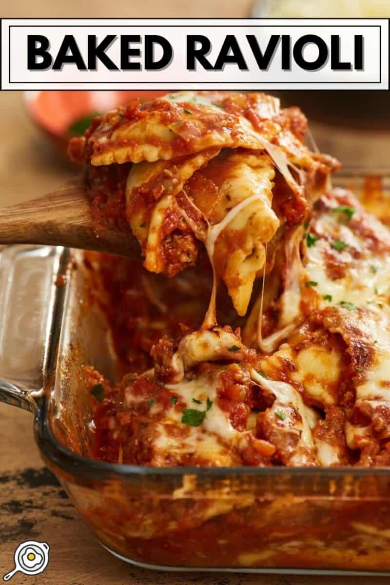 Baked ravioli being lifted out of a casserole dish.