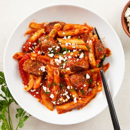 Overhead view of a bowl full of pasta with sausage and peppers.