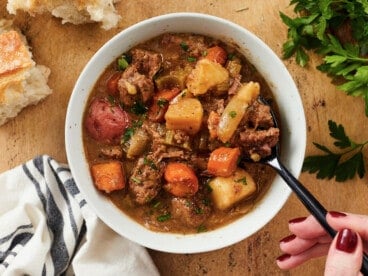 Overhead view of a bowl of beef stew with a spoon.