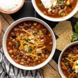 Overhead view of three bowls of taco soup with different toppings.