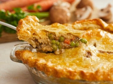 Side shot of a slice of vegetable pot pie being removed from the pie dish.
