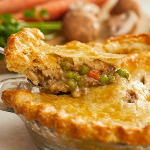 Side shot of a slice of veggie pot pie being removed from the pie dish.