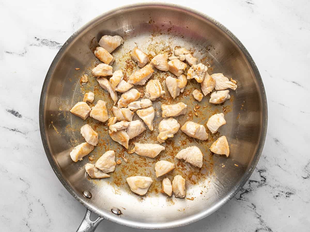 Cooked chunks of chicken in a skillet.
