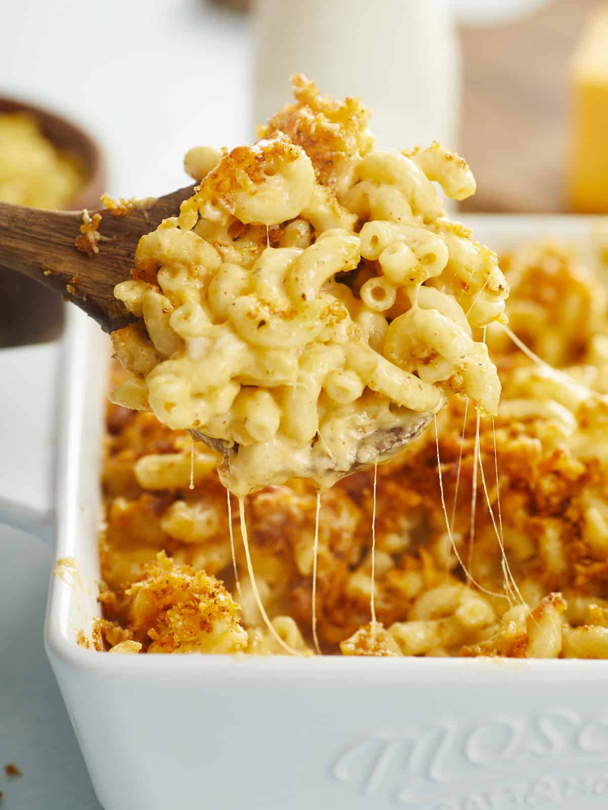 Side view of macaroni and cheese being lifted out of the casserole dish.