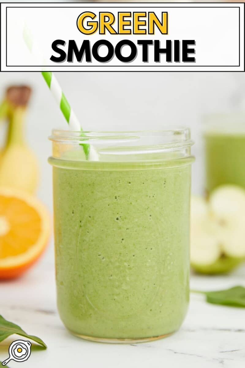 Side view of a green smoothie in a mason jar with a striped straw.