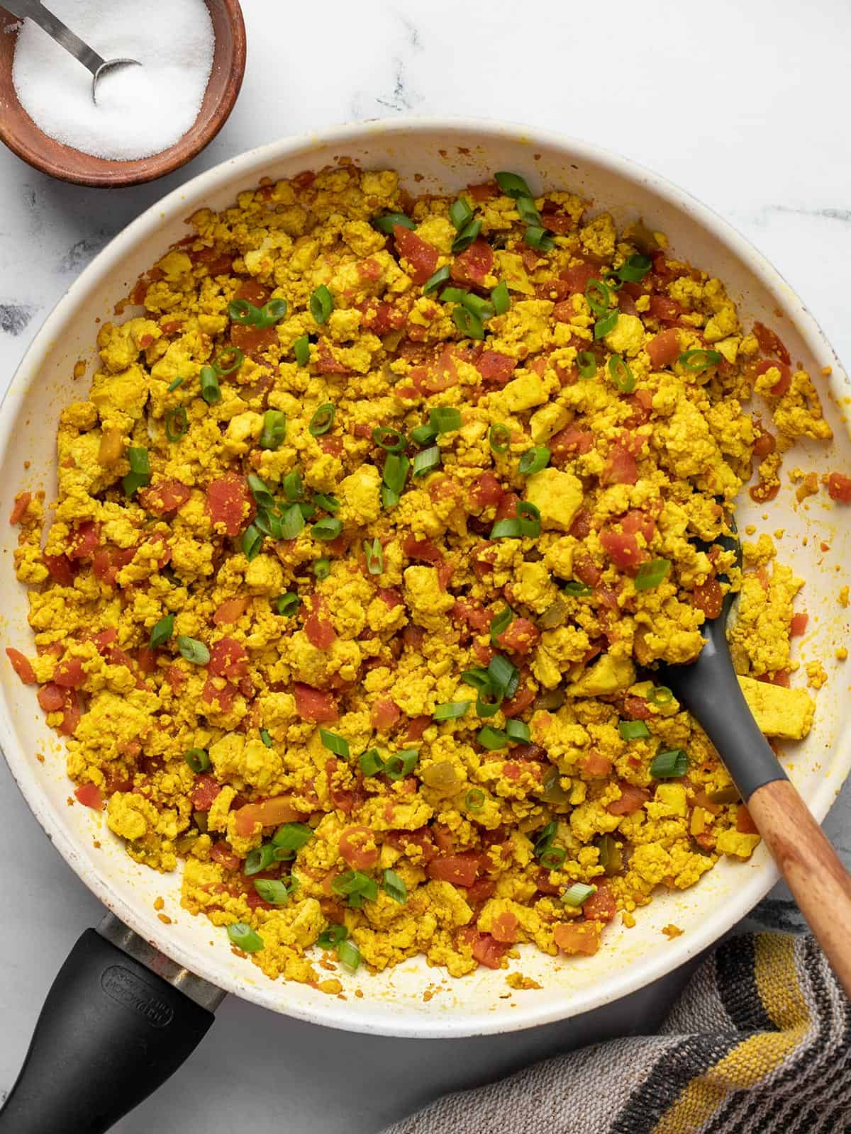 Overhead view of southwest tofu scramble in a skillet with a spatula.