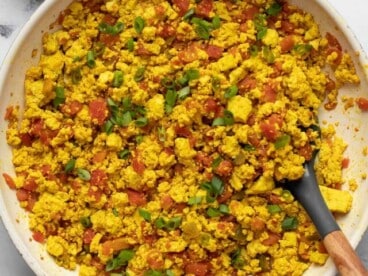 Overhead view of southwest tofu scramble in a skillet with a spatula.