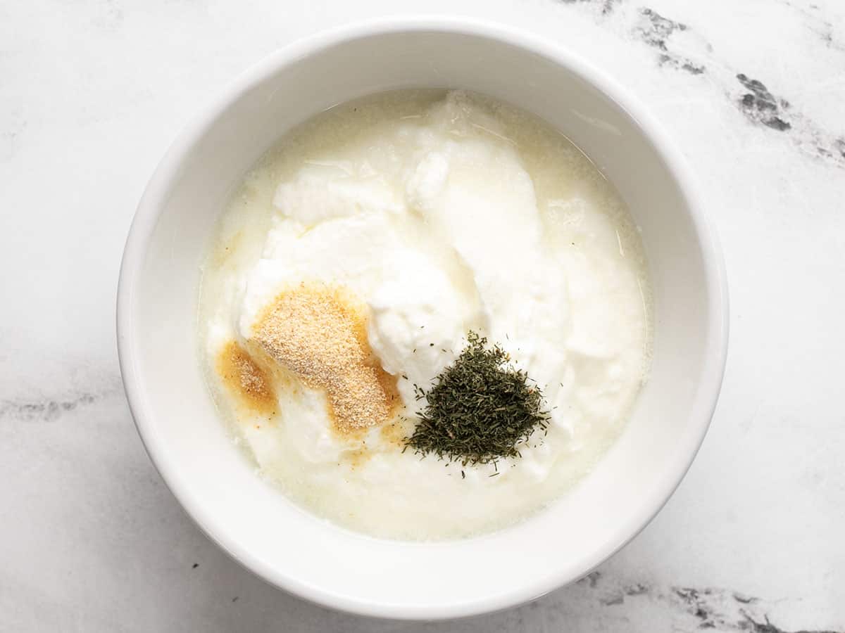Garlic dill yogur sauce ingredients in a bowl, unstirred.