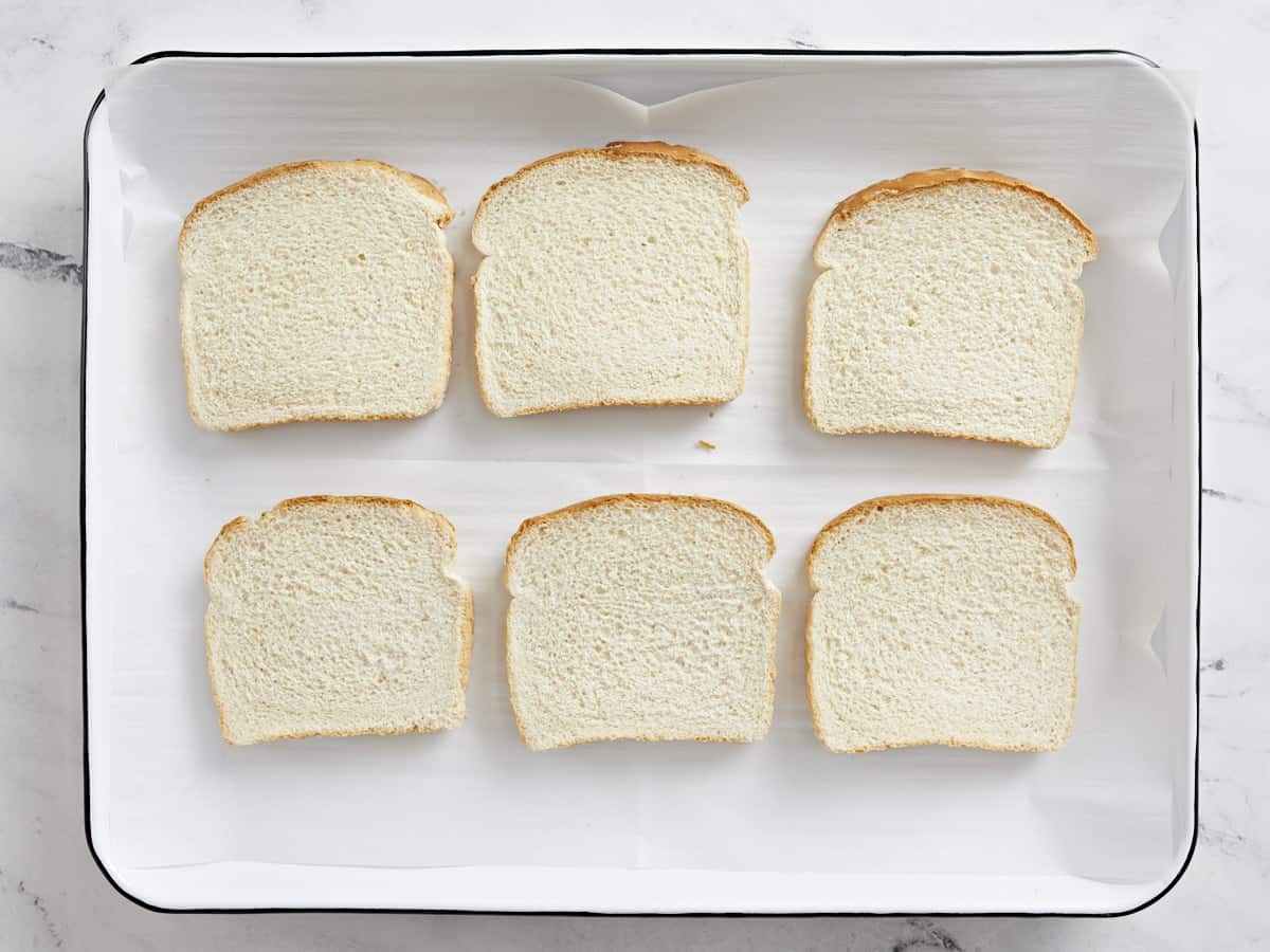 Sliced bread on a baking sheet for freezing.