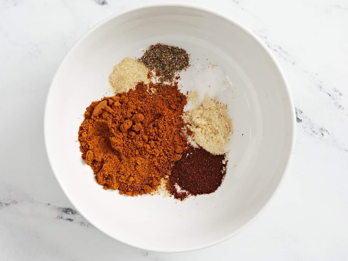 Overhead shot of the spices that make up Nashville Hot Seasoning in a white bowl.