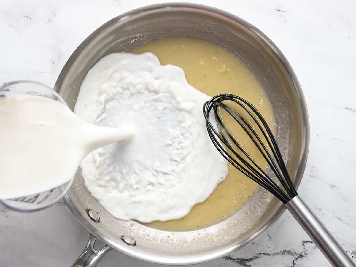 Milk being poured into the roux.