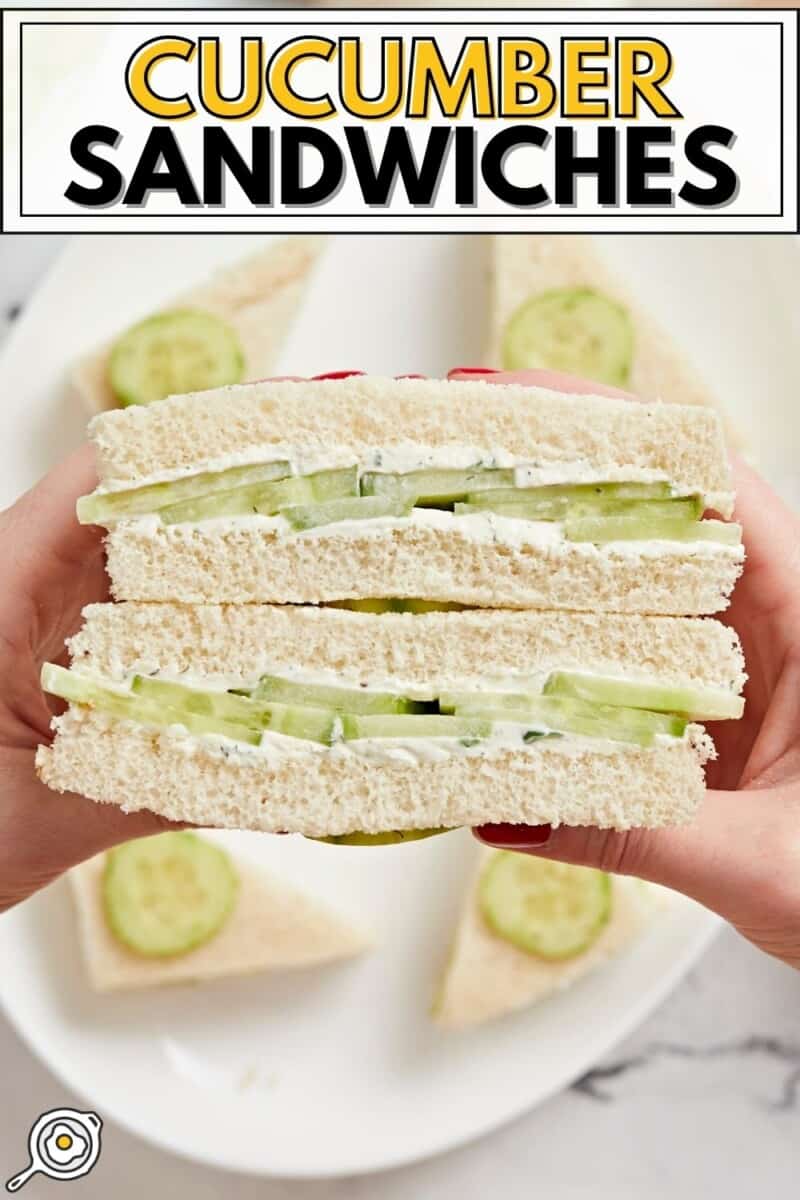 Close up view of a cross section of cucumber sandwiches held in a hand.