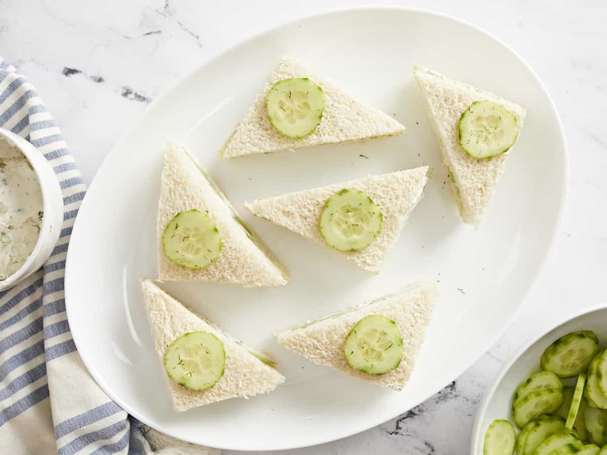 Overhead view of cucumber sandwiches on a plate.