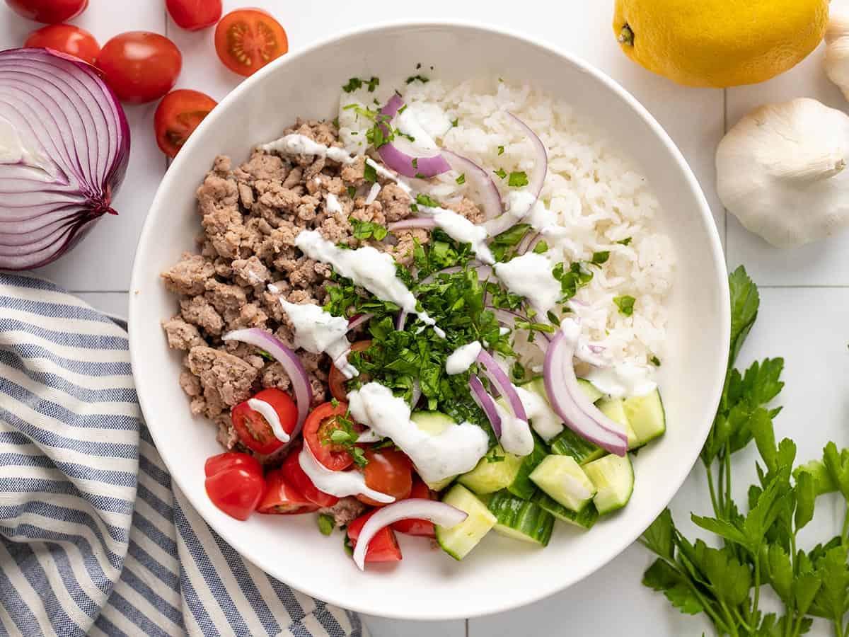 Overhead view of a Mediterranean Turkey Bowl with yogurt sauce drizzled over top.