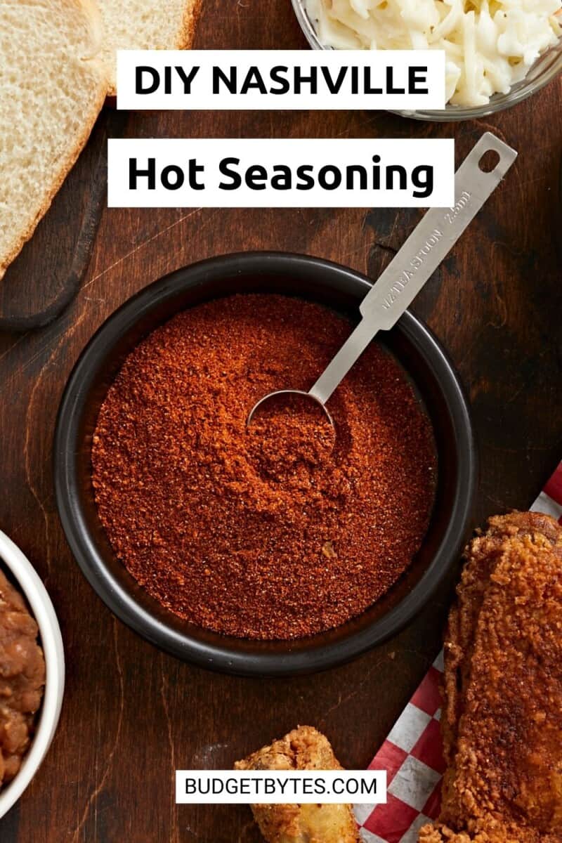 Overhead shot of Nashville Hot Seasoning in a black bowl with a silver measuring spoon in it.