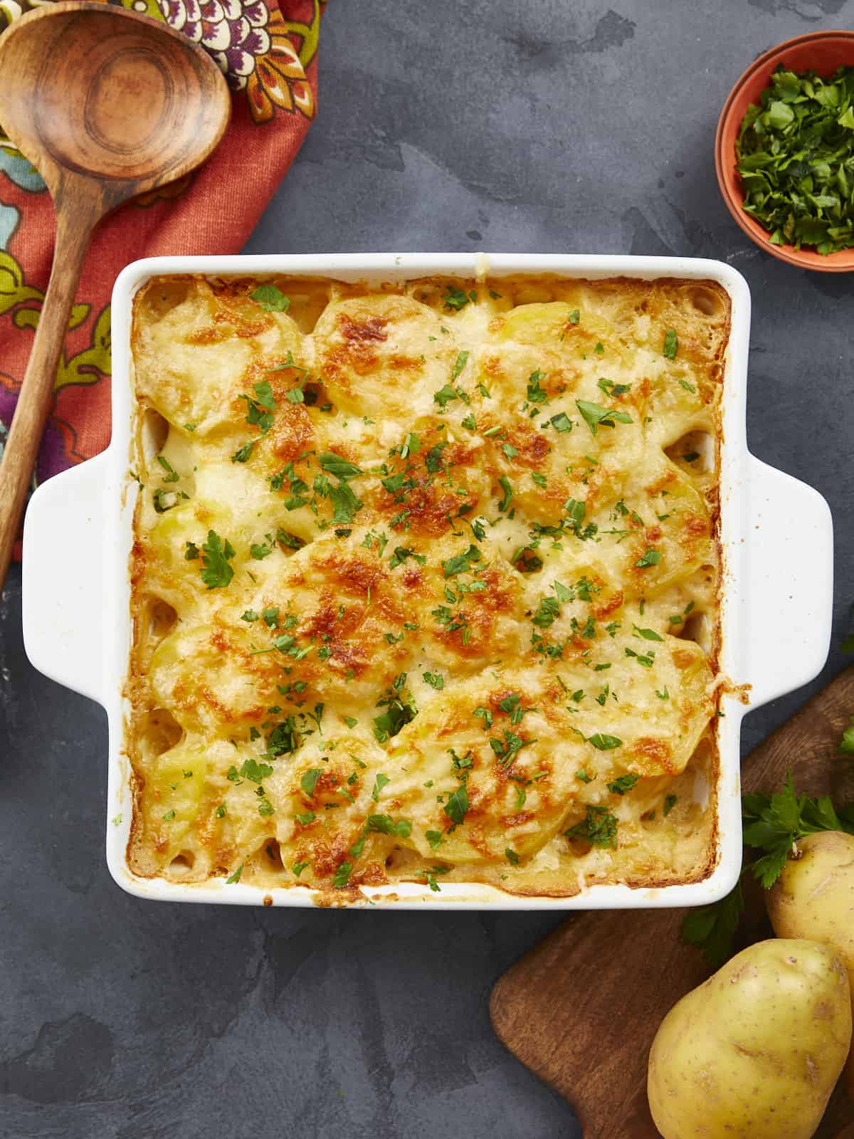 Overhead shot of scalloped potatoes in a white casserole dish.