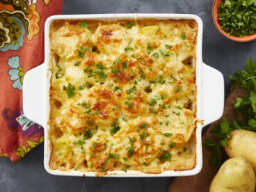 Overhead shot of scalloped potatoes in a white casserole dish.