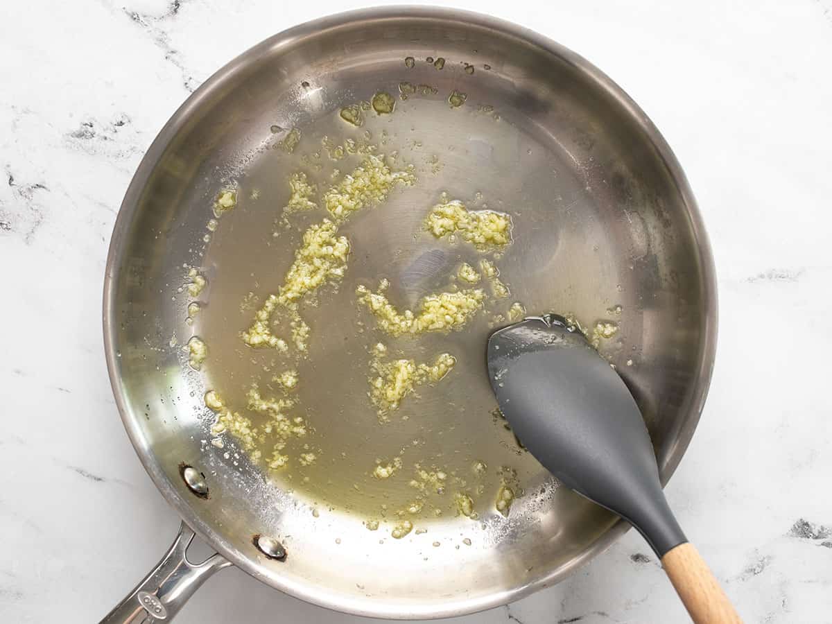 Sautéed garlic in a skillet with olive oil.