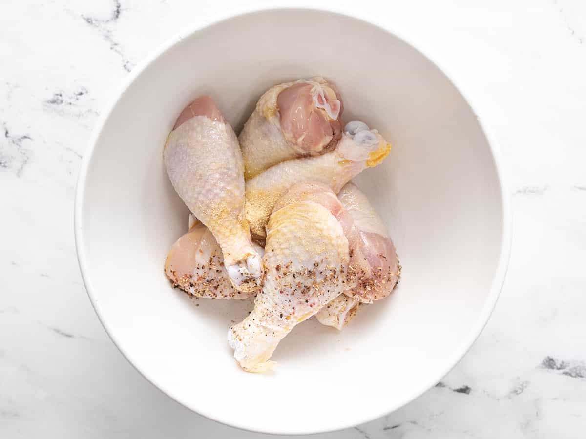 Seasoned drumsticks in a bowl.